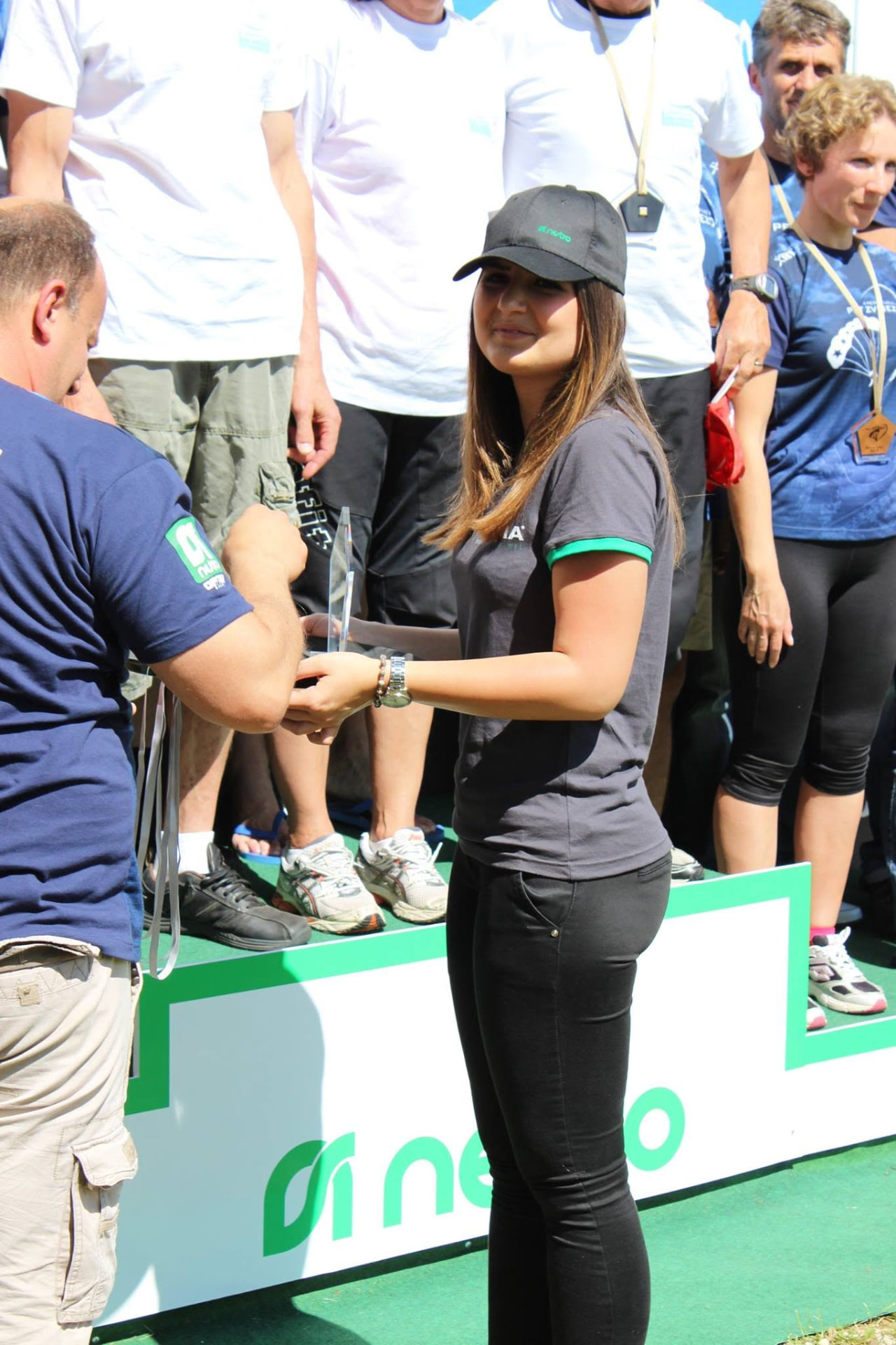 A club volunteer presenting a trophy to a competitor at an event organised by the club