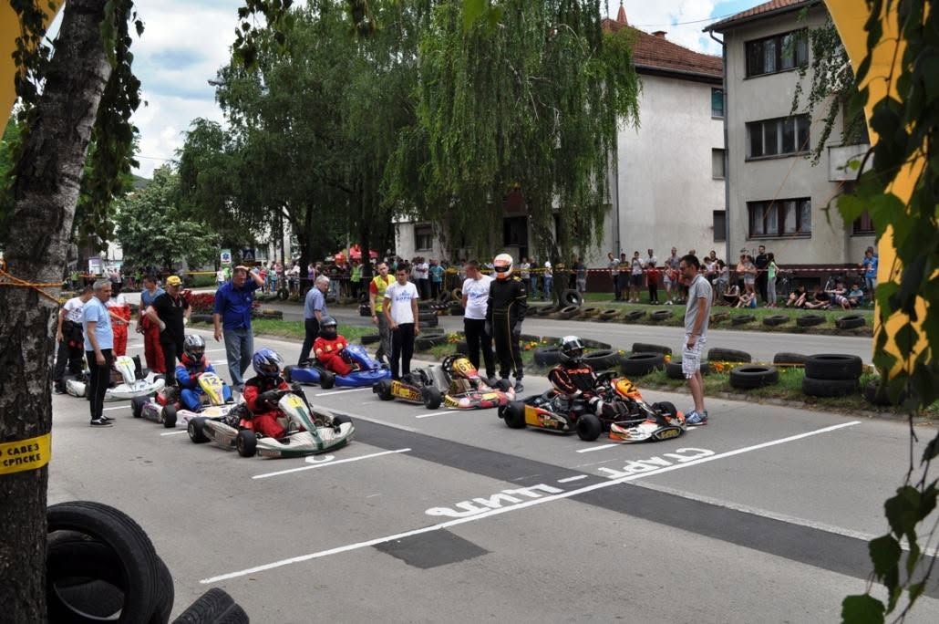 Young drivers lined up on the starting grid of a closed city-street karting race
