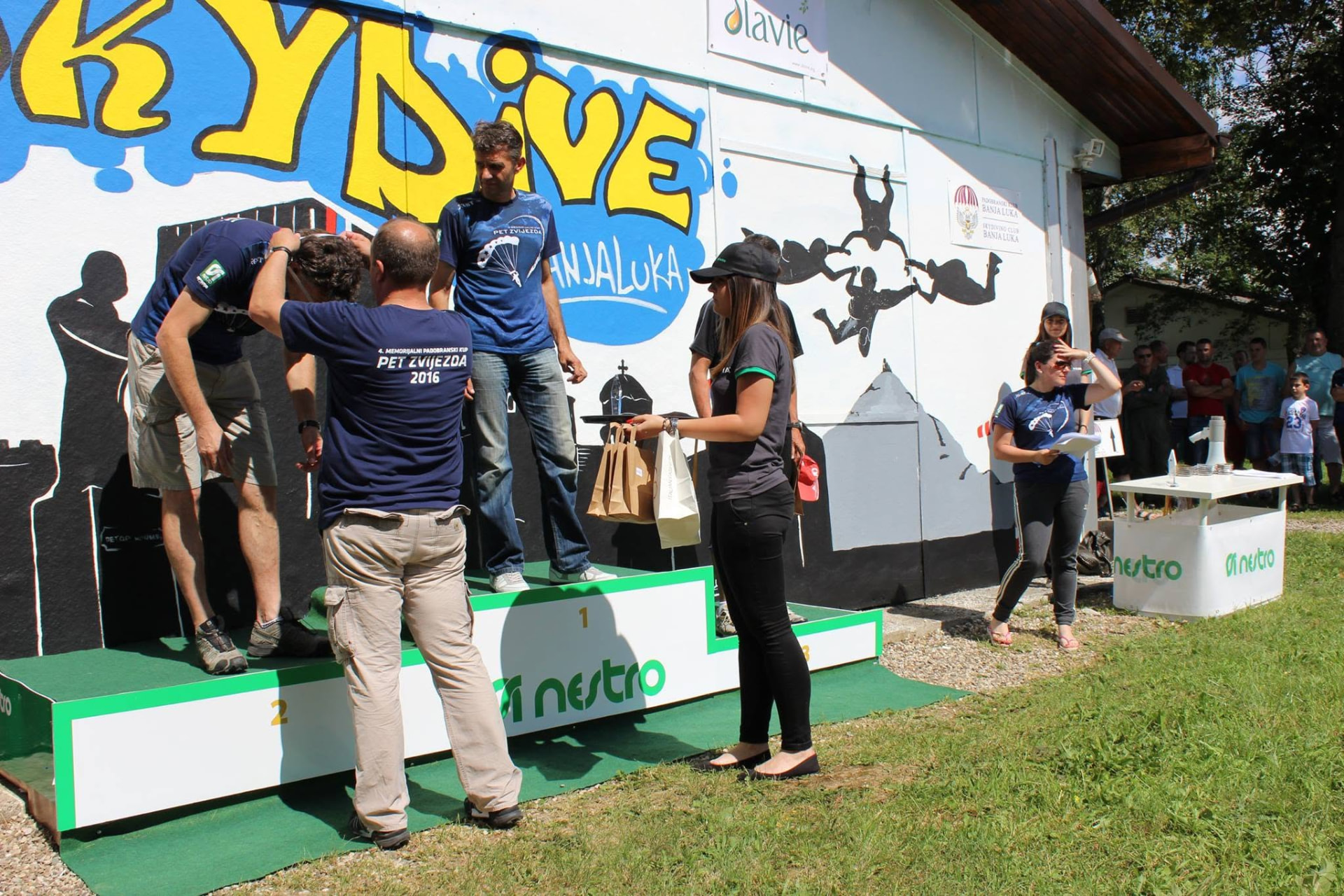 Volunteers handing awards to competitors on the podium at a club-organised event